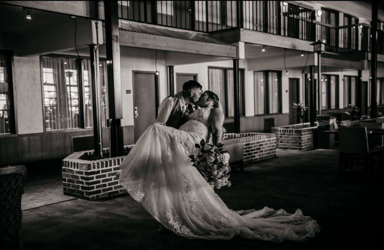 Black and white photo of a bride and groom embracing in the courtyard at Wyndham Garden York