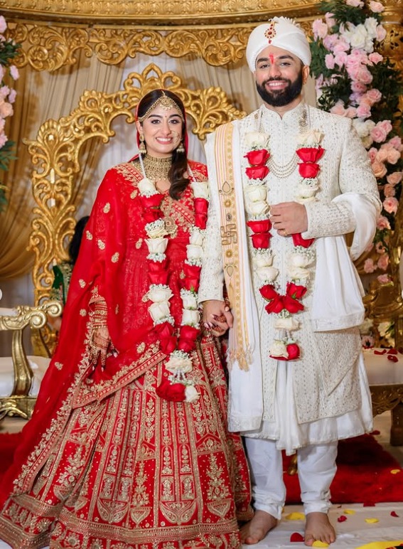 Bride and groom wearing flower garlands on a gold mandap stage at their Hindu wedding ceremony at Wyndham Garden York