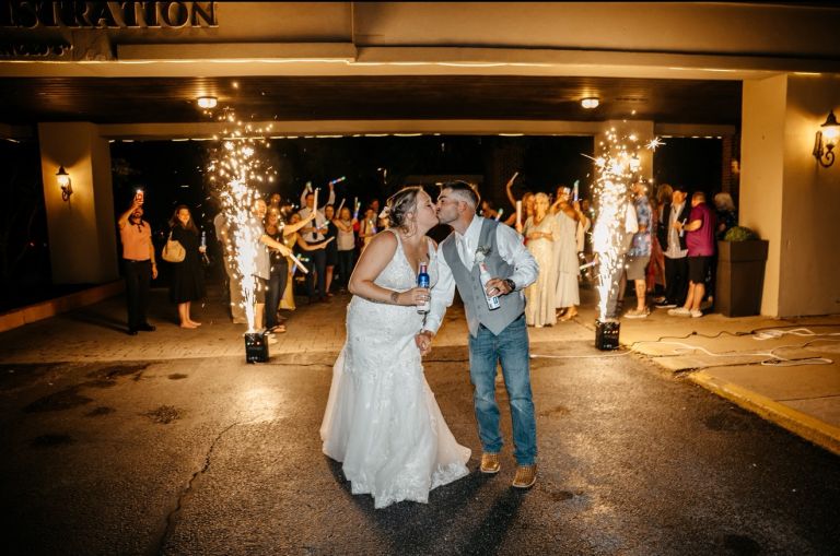 Newlyweds kissing during a sparkler send-off under the hotel entrance at Wyndham Garden York
